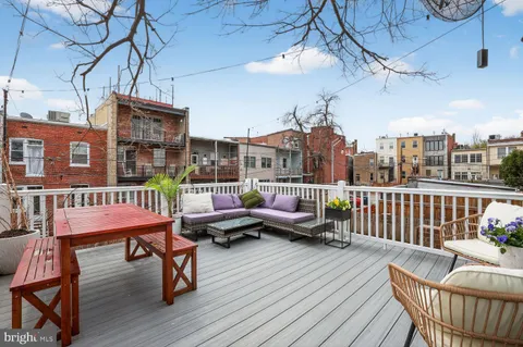 a balcony with wooden benches and couches