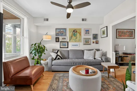 a living room with furniture a rug and a window