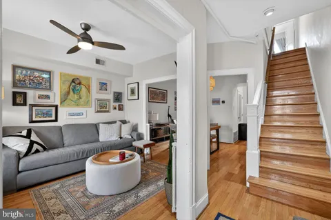 a living room with furniture and a wooden floor