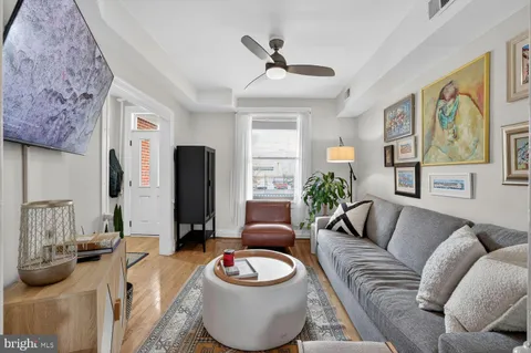 a living room with furniture and a wall painting
