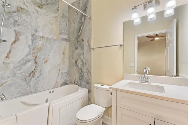 a bathroom with a sink toilet vanity and shower