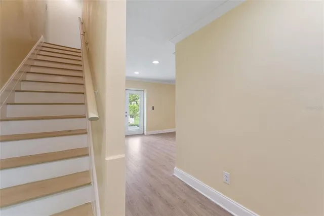 a view of a hallway with wooden floor and entryway