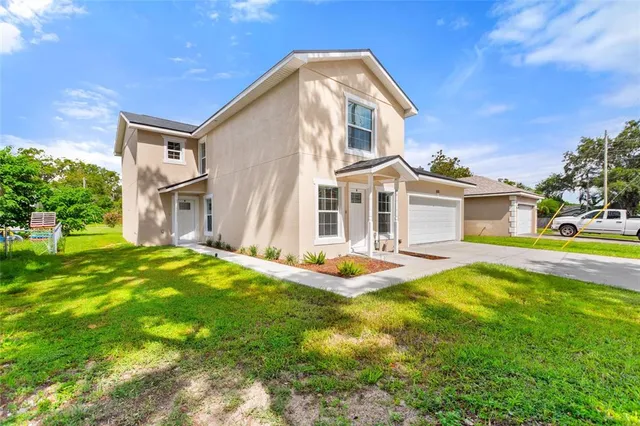 a front view of a house with yard and green space