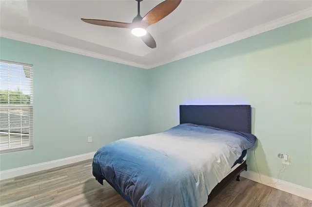 a bedroom with a large bed and a ceiling fan