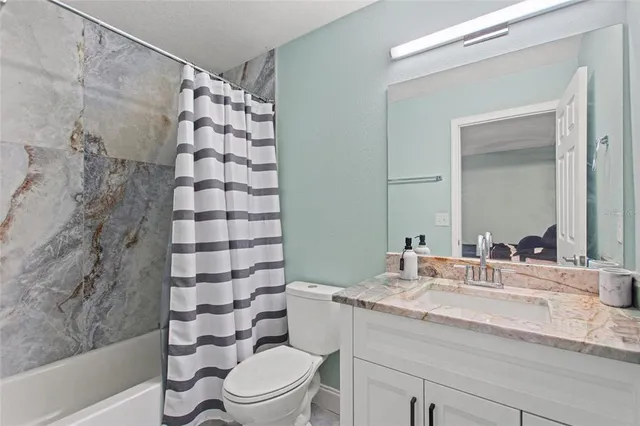 a bathroom with a sink a toilet and shower curtain