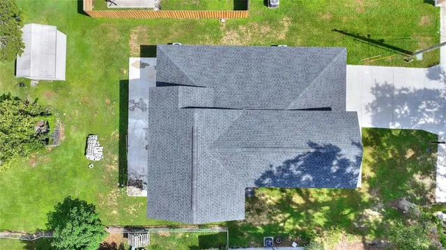 an aerial view of house with yard and parking