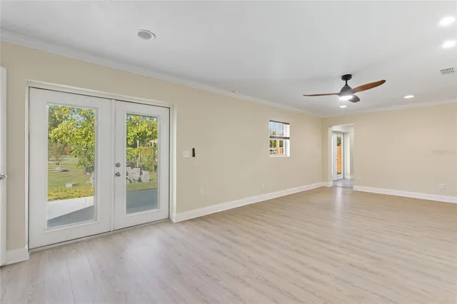 an empty room with wooden floor and windows