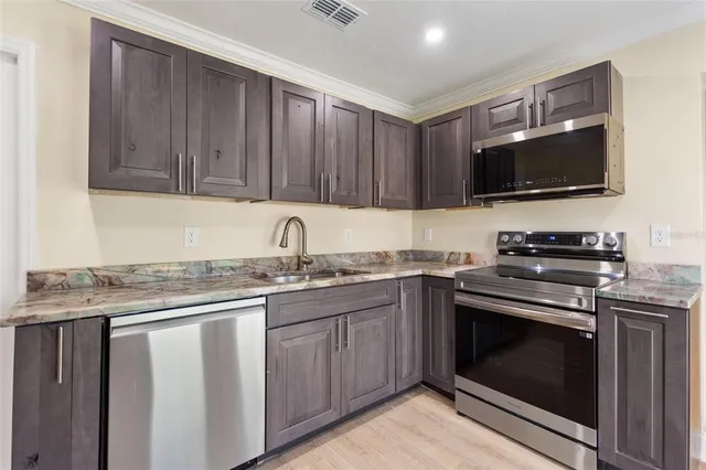 a kitchen with granite countertop a stove sink and cabinets