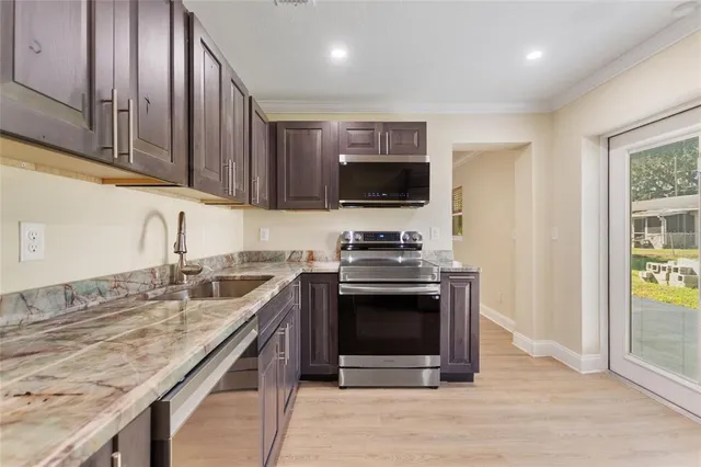 a kitchen with stainless steel appliances granite countertop a stove microwave and sink