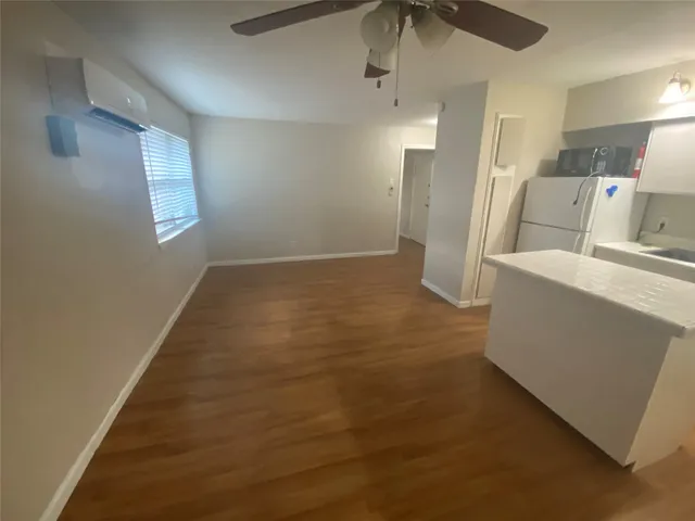 a view of a kitchen with a sink and a refrigerator