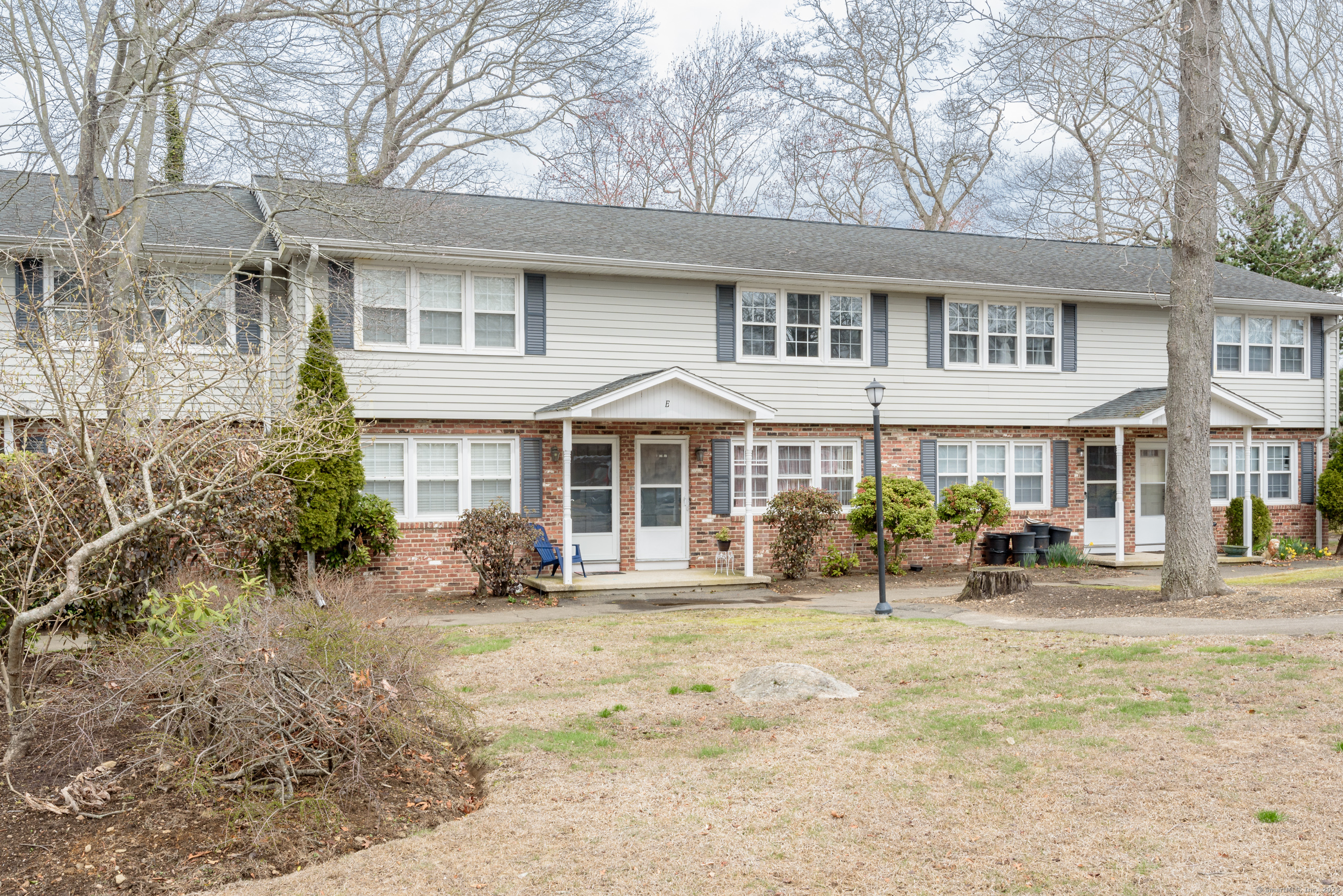 280 East Main Street, Unit E6 Clinton, CT 06413 - Photo 2 of 33 a front view of a house with a yard patio and fire pit