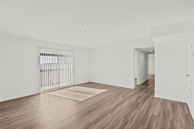 a view of a room with wooden floor and white walls