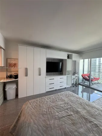 a bedroom with a bed and furniture with a flat tv screen