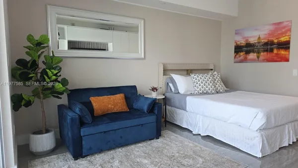 a bedroom with a bed and a potted plant