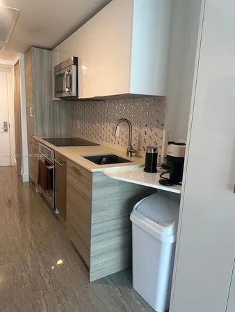 a kitchen with a sink and a stove top oven