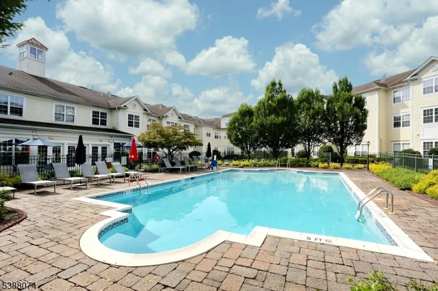 a view of swimming pool with outdoor seating and yard in the back