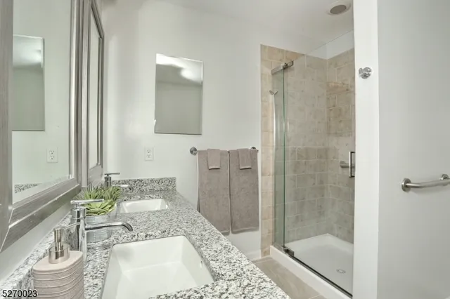 a bathroom with a granite countertop sink a toilet and shower