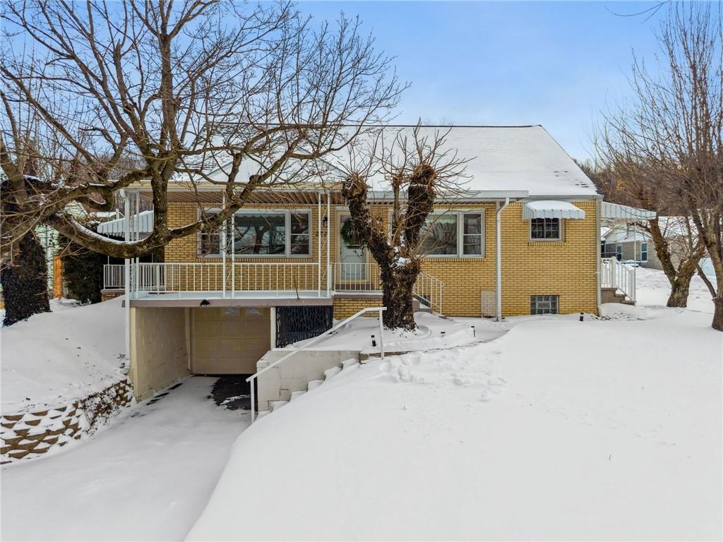 a view of a house with a yard covered in snow