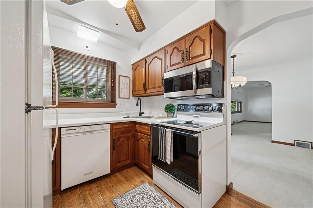 224 Old Rte 217 Derry, PA 15627 - Photo 8 of 47 a kitchen with stainless steel appliances granite countertop a stove top oven a sink a refrigerator white cabinets and wooden floor