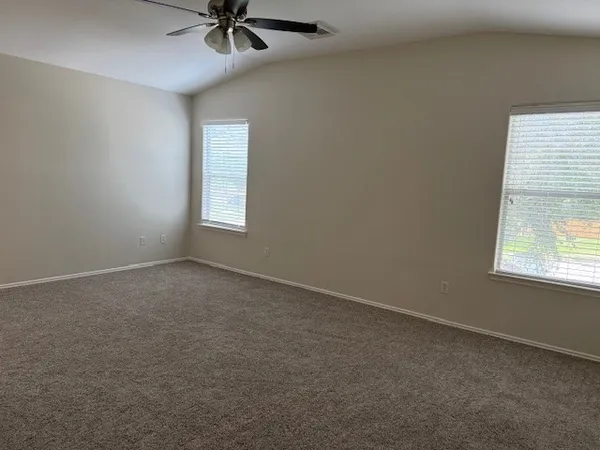 an empty room with a window and a ceiling fan