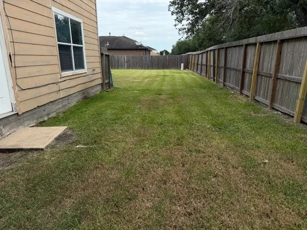 a view of backyard with wooden fence
