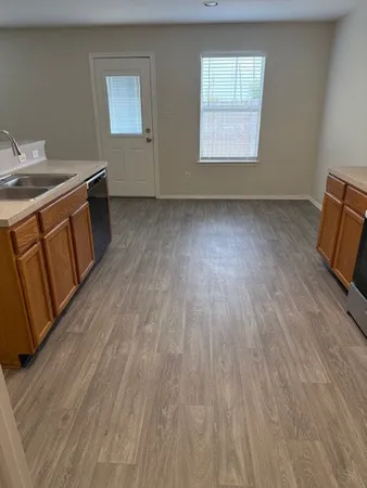 a view of a room with wooden floors and window