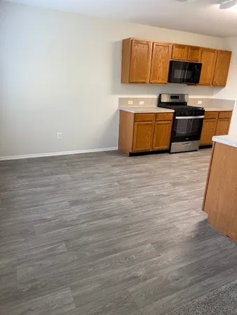 a view of kitchen with stainless steel appliances granite countertop refrigerator sink and stove