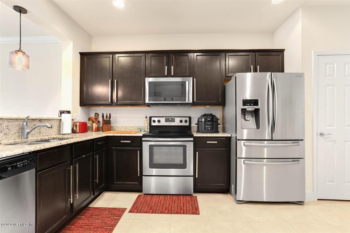 6864 Roundleaf Drive Jacksonville, FL 32258 - Photo 7 of 17 a kitchen with stainless steel appliances granite countertop a refrigerator and a sink