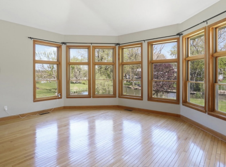 408 South Spring Lake Road Mahomet, IL 61853 - Photo 22 of 64 a view of an empty room with glass windows and a floor to ceiling window with wooden floor