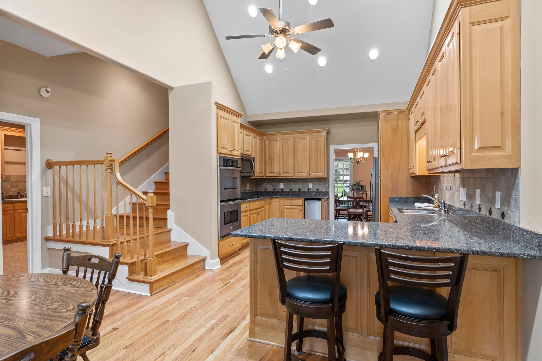 545 Pickney Road Winchester, TN 37398 - Photo 14 of 39 a kitchen with stainless steel appliances granite countertop a stove a refrigerator a sink dishwasher a dining table and chairs with wooden floor