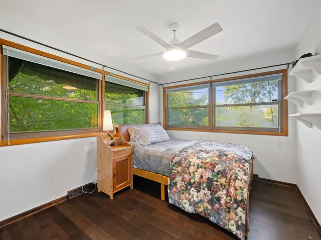 a bedroom with a bed and a large window with outer view