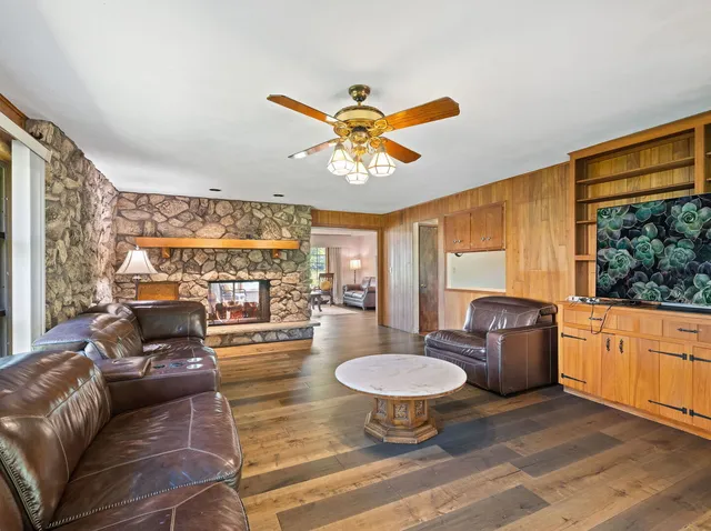 a living room with furniture a fireplace and a large window