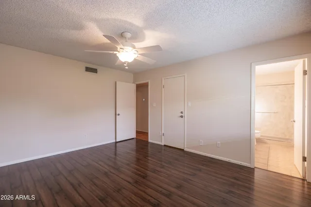 a view of a room with wooden floor and a ceiling fan