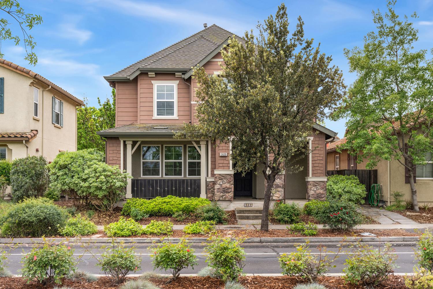 a front view of a house with a yard and potted plants
