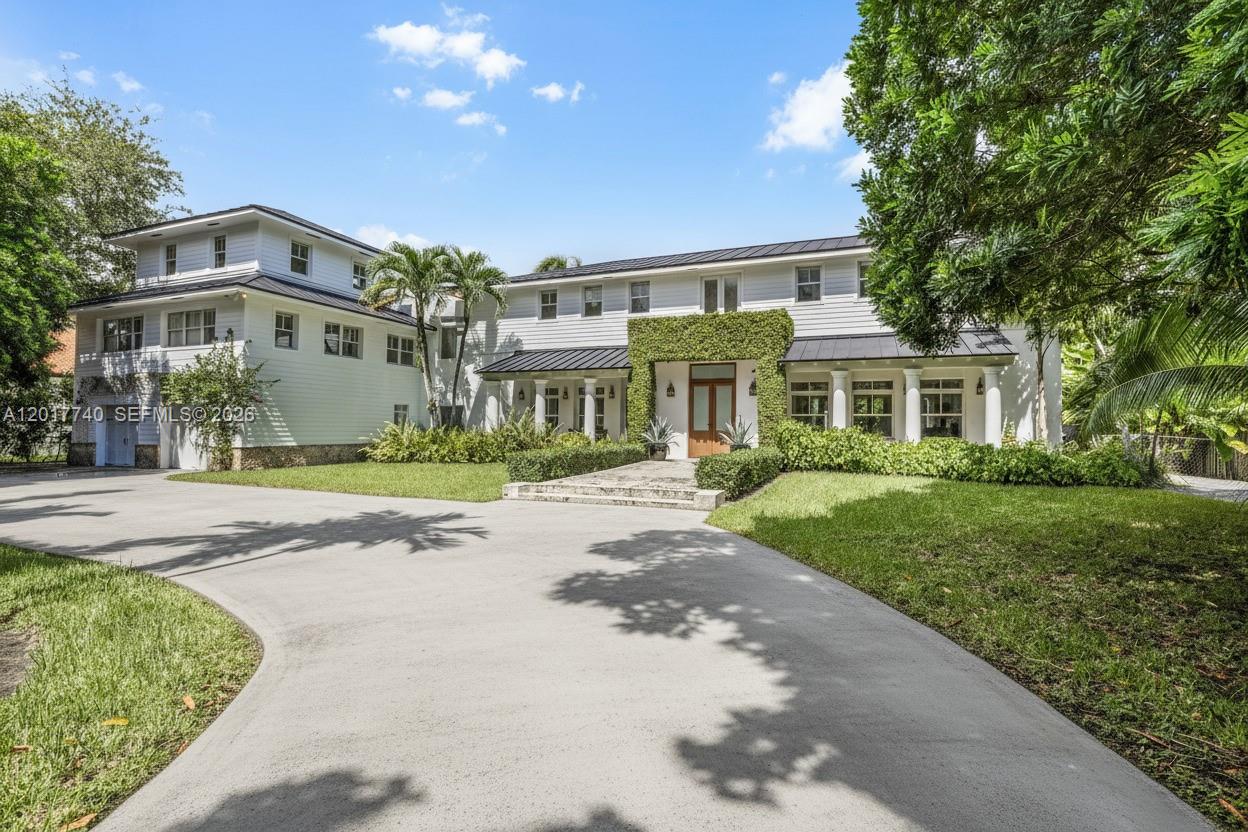 6845 Southwest 98th Street Pinecrest, FL 33156 - Photo 1 of 23 a front view of a house with a yard and pathway