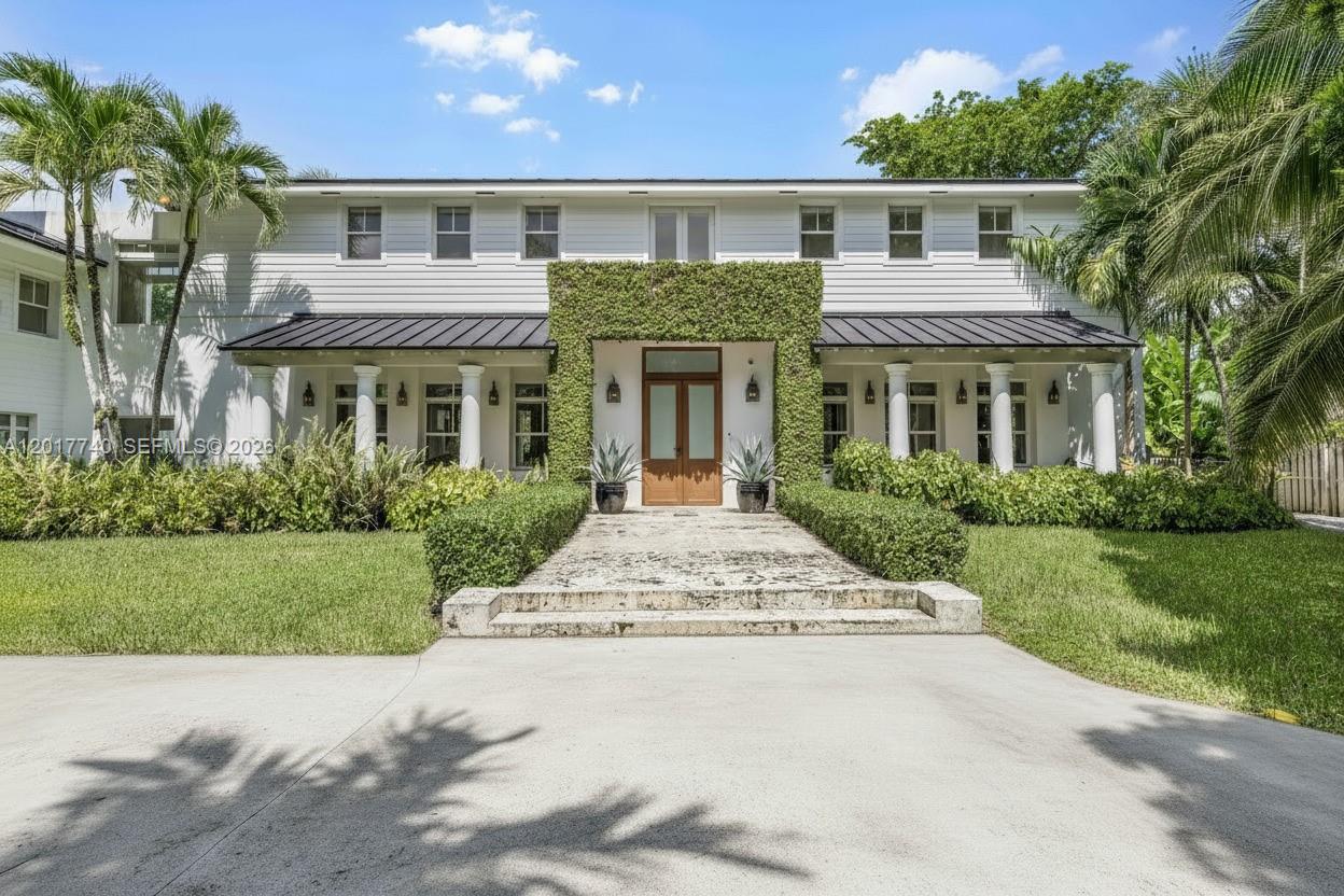 6845 Southwest 98th Street Pinecrest, FL 33156 - Photo 2 of 23 a front view of a house with a garden