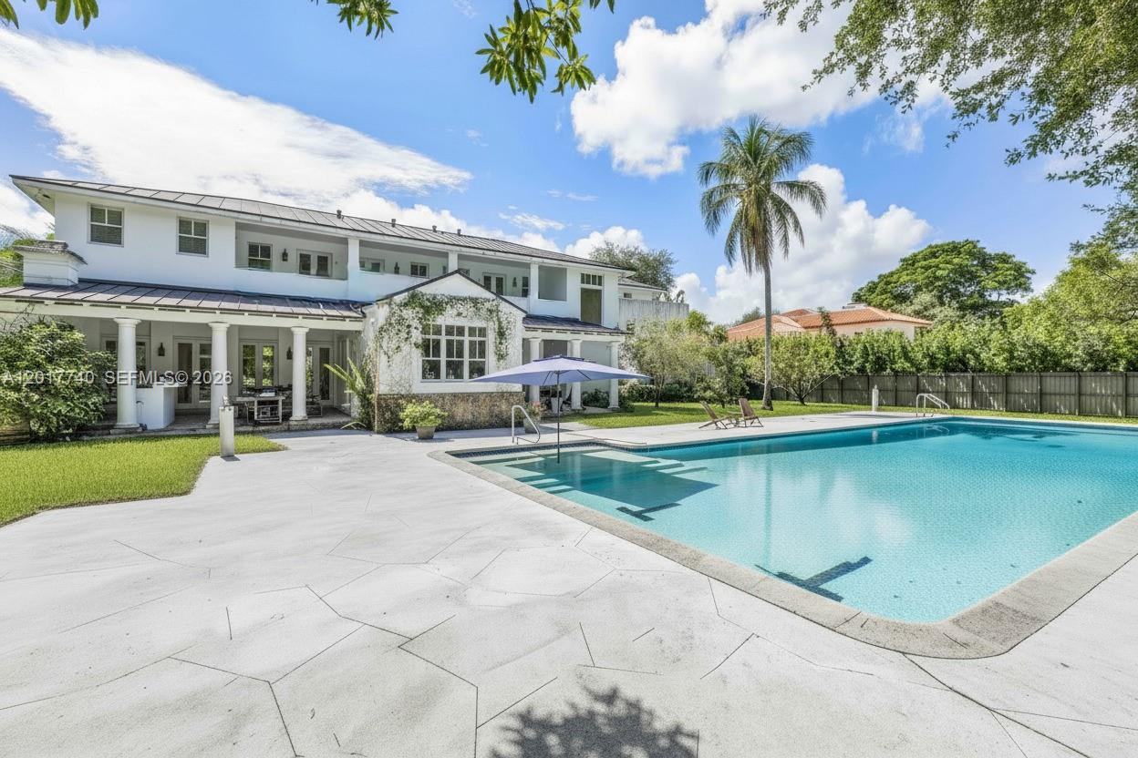 6845 Southwest 98th Street Pinecrest, FL 33156 - Photo 21 of 23 a view of a house with a swimming pool and a patio