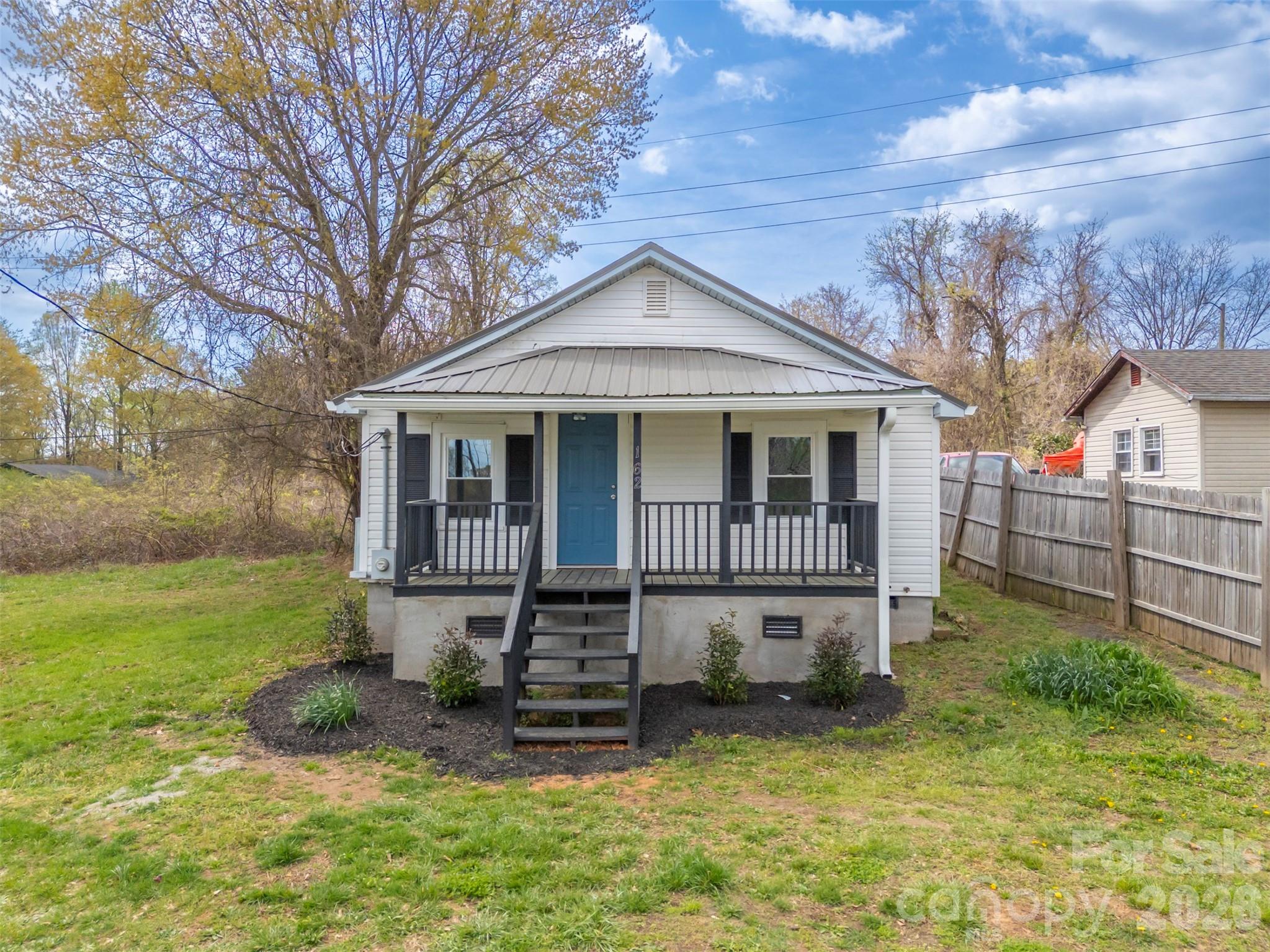 a view of a house with a yard and fence