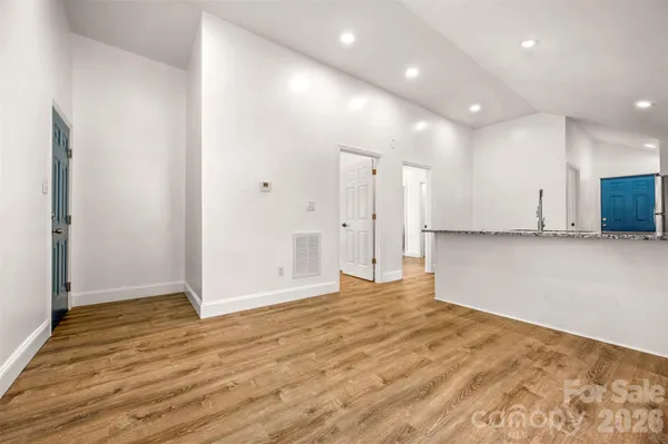 a view of an empty room with wooden floor