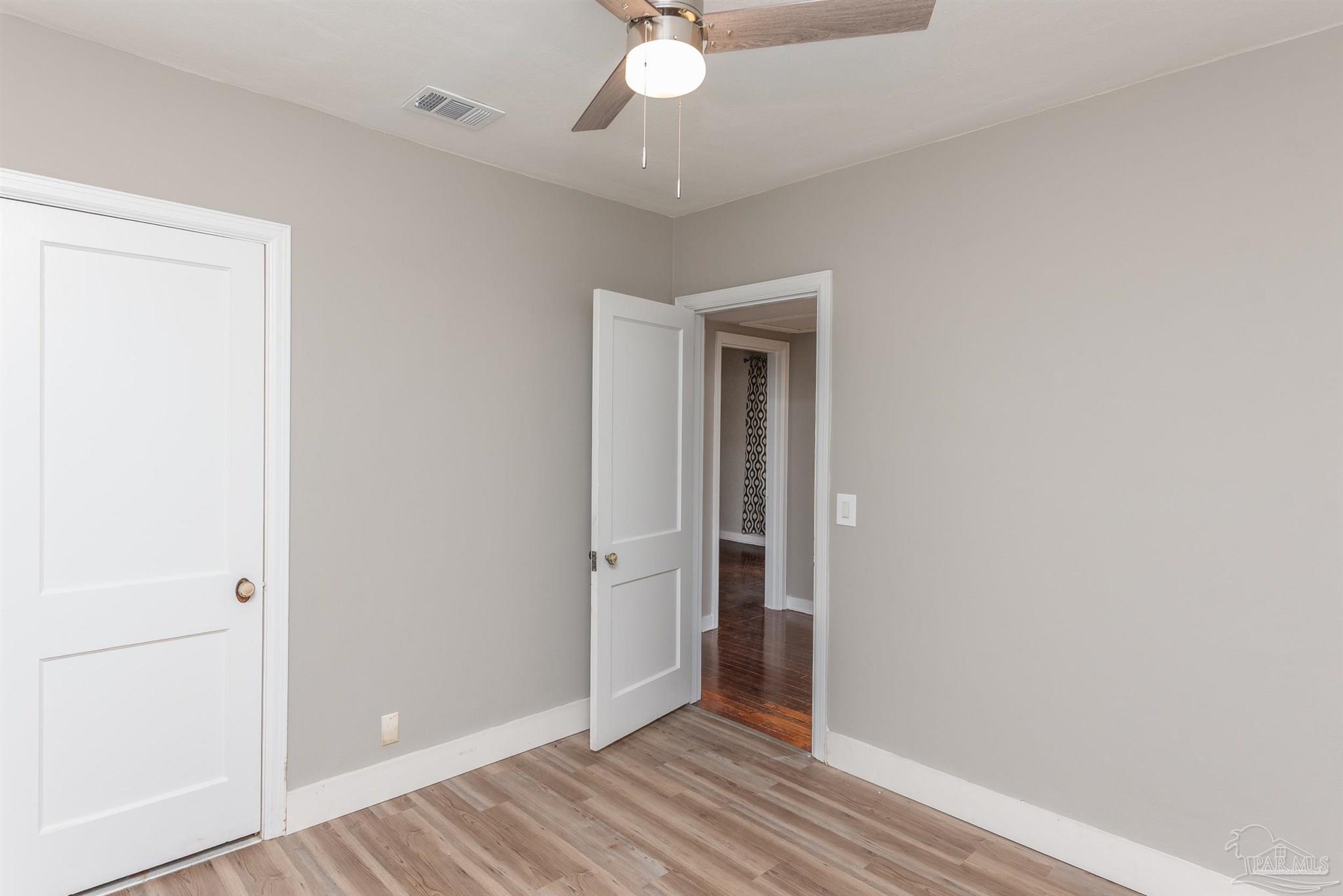 225 Bryant Road Pensacola, FL 32507 - Photo 11 of 21 an empty room with wooden floor and fan
