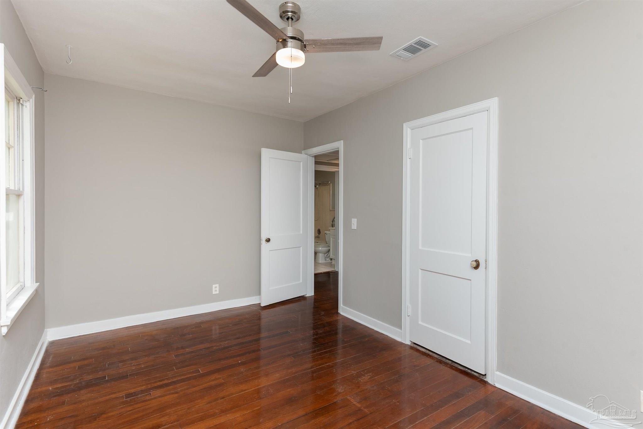 225 Bryant Road Pensacola, FL 32507 - Photo 13 of 21 an empty room with wooden floor and windows