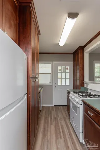 a kitchen with a stove a refrigerator and a window