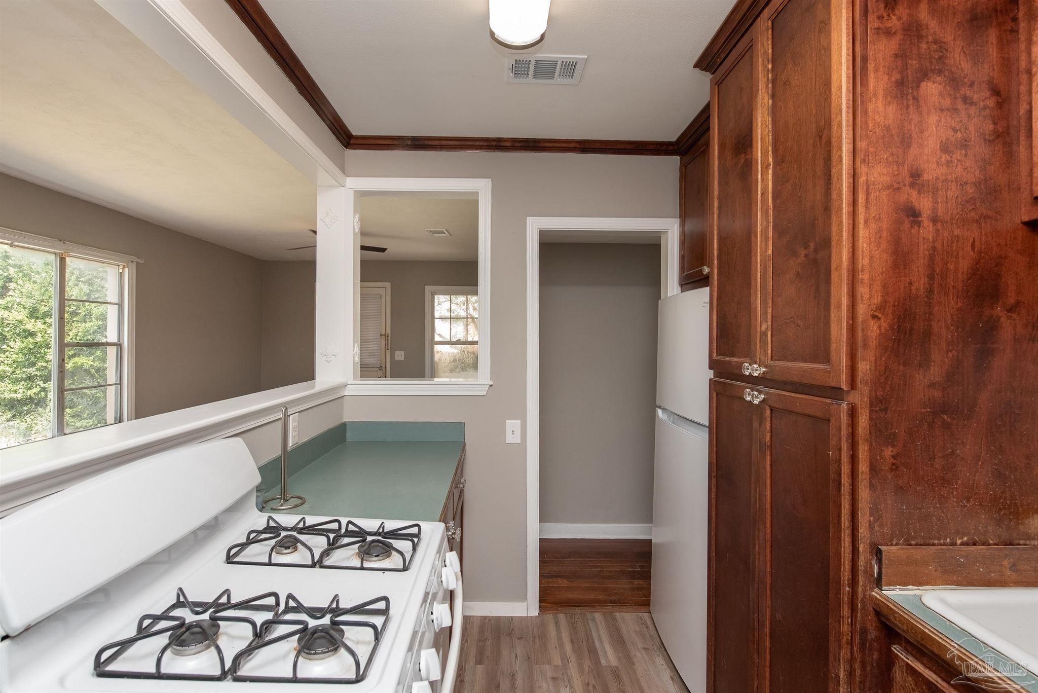 225 Bryant Road Pensacola, FL 32507 - Photo 7 of 21 a view of a hallway with wooden floor and a bathroom