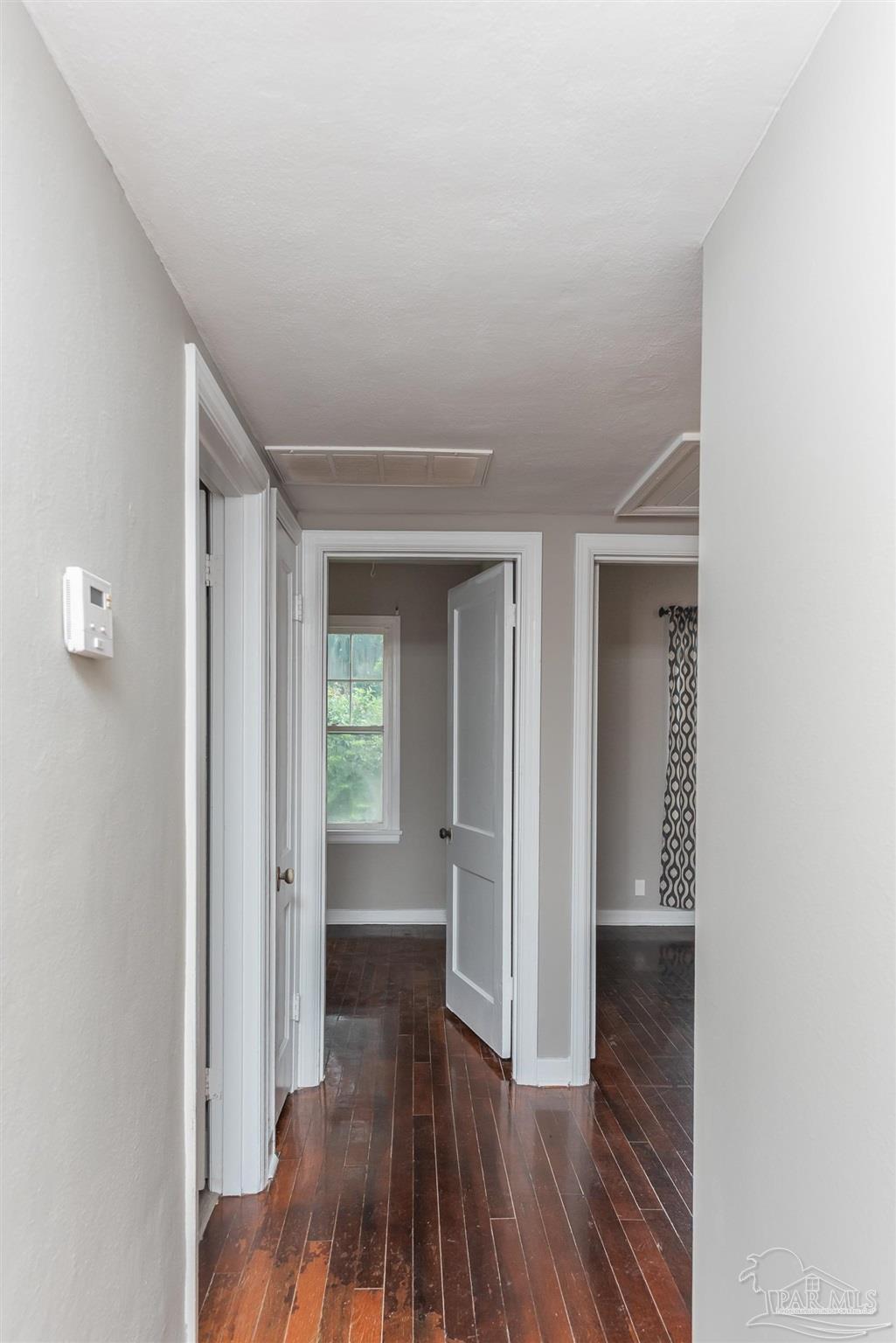 225 Bryant Road Pensacola, FL 32507 - Photo 9 of 21 a view of a hallway with wooden floor and a bathroom