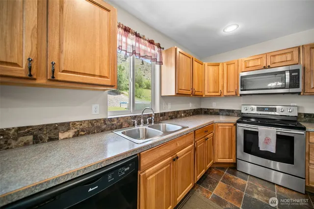 a kitchen with stainless steel appliances granite countertop a refrigerator and a stove top oven