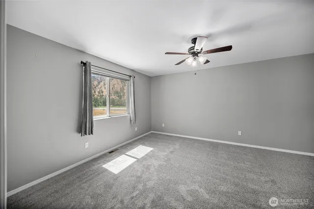 a view of a big room with windows and chandelier fan