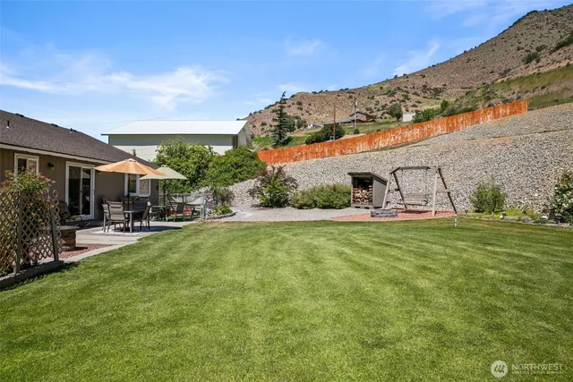 a view of a patio with a table and chairs under an umbrella