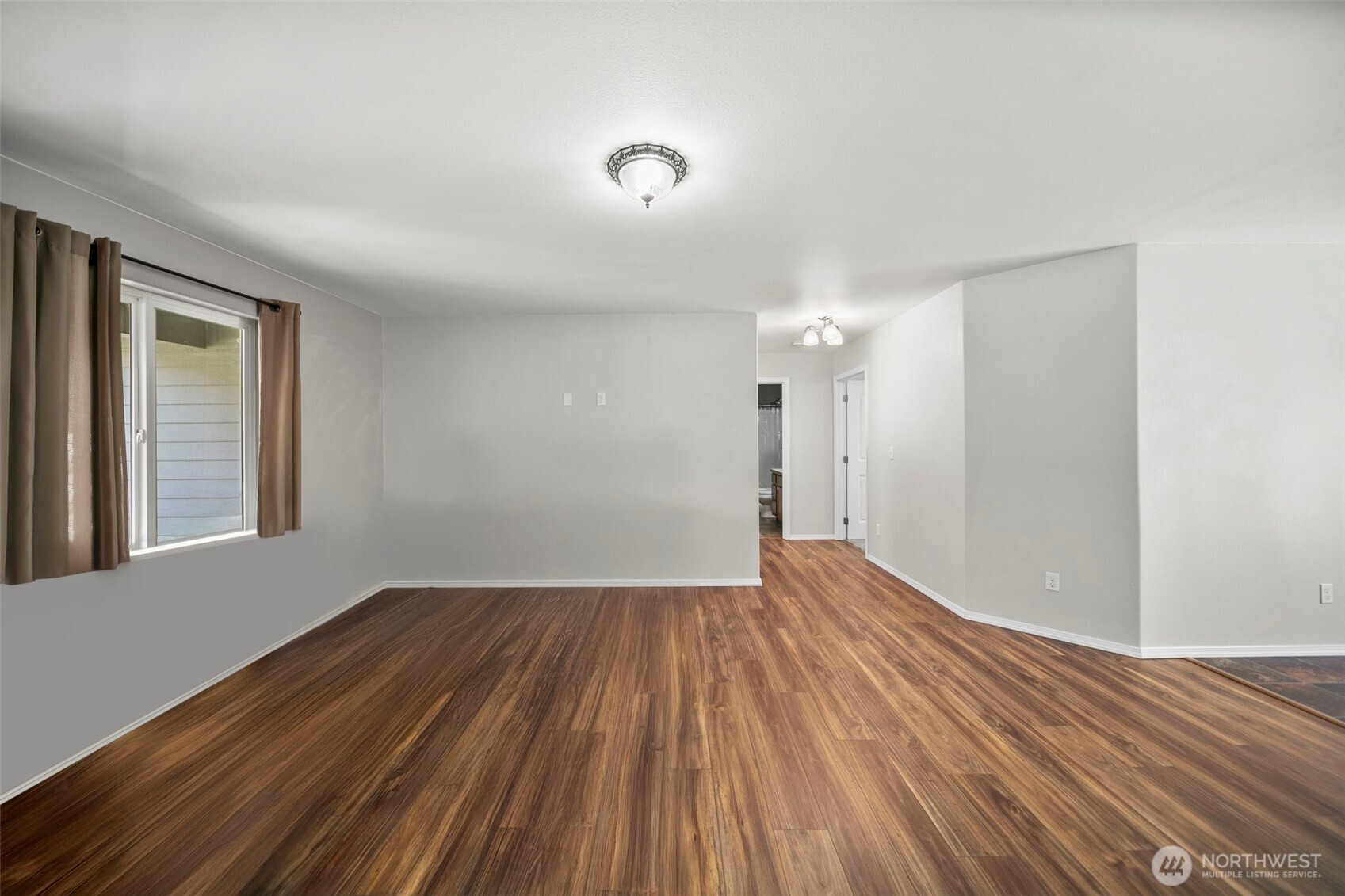 6132 Entiat River Road Entiat, WA 98822 - Photo 6 of 40 a view of an empty room with wooden floor and a window