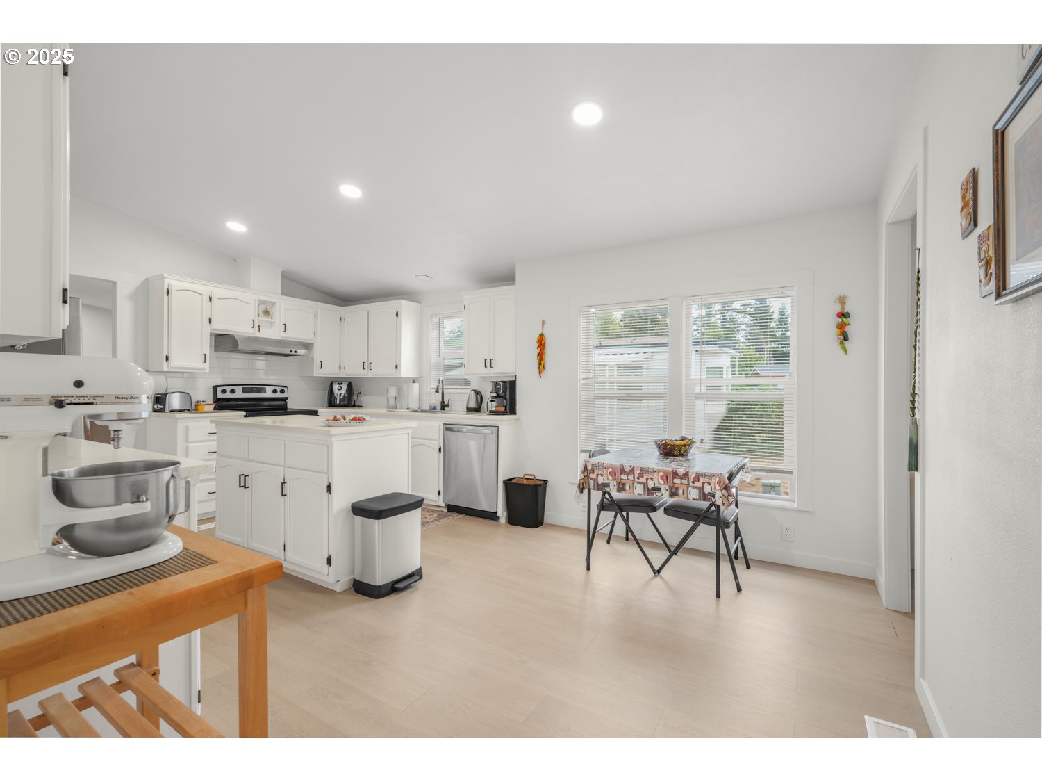 18780 South Central Point Road, Unit 19 Oregon City, OR 97045 - Photo 14 of 25 a kitchen with white cabinets and chairs