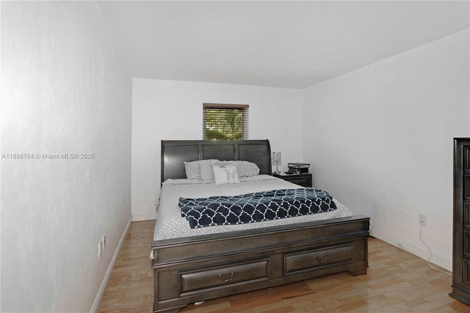 8617 Southwest 68th Court, Unit 24 Pinecrest, FL 33156 - Photo 20 of 24 a bedroom with a bed and a night stand